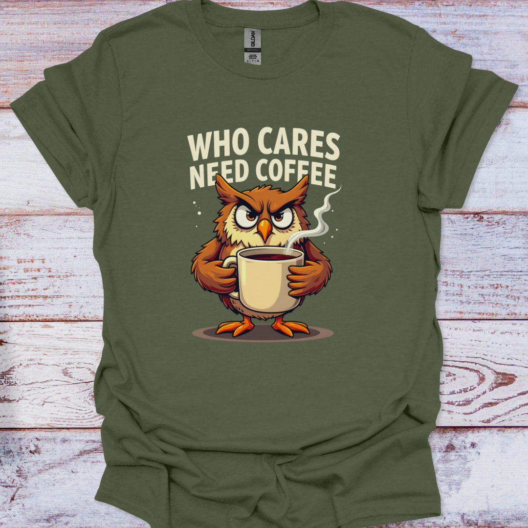 Green t-shirt with an owl holding a coffee cup and text 'WHO CARES NEED COFFEE' on a wooden surface.