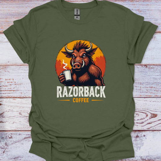 Green t-shirt with a graphic of a boar holding a coffee cup and 'Razorback Coffee' text on a wooden surface.