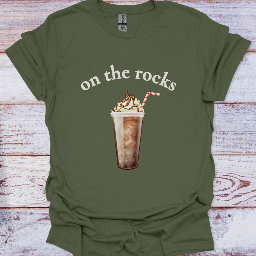 Green t-shirt with 'on the rocks' and a coffee graphic on a wooden surface