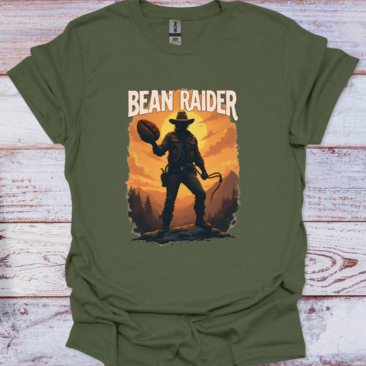 Green t-shirt with a graphic of a cowboy and 'Bean Raider' text on a wooden surface