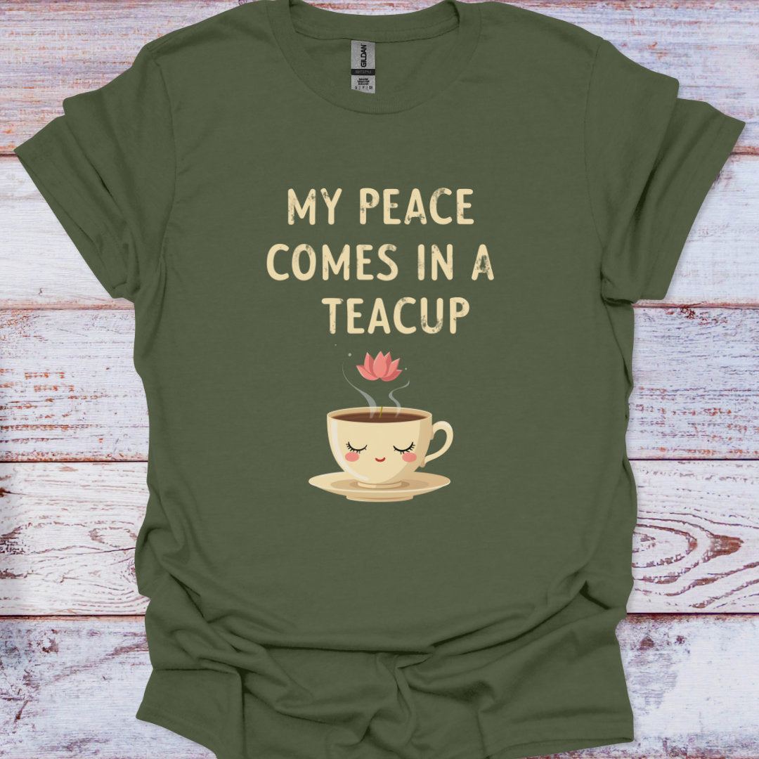 Green t-shirt with a teacup graphic and text 'My peace comes in a teacup' on a wooden surface.