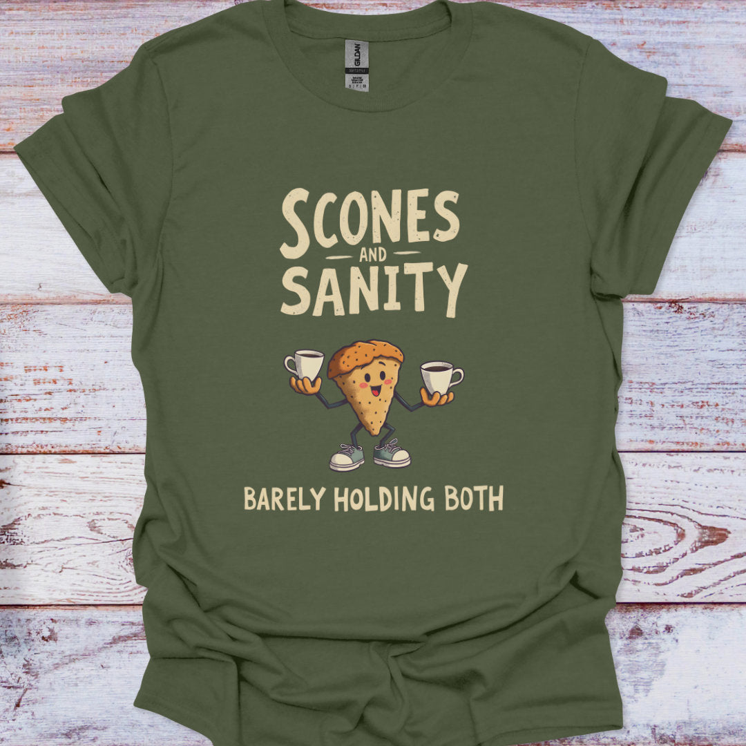Green t-shirt with 'Scones and Sanity Barely Holding Both' graphic on a wooden surface