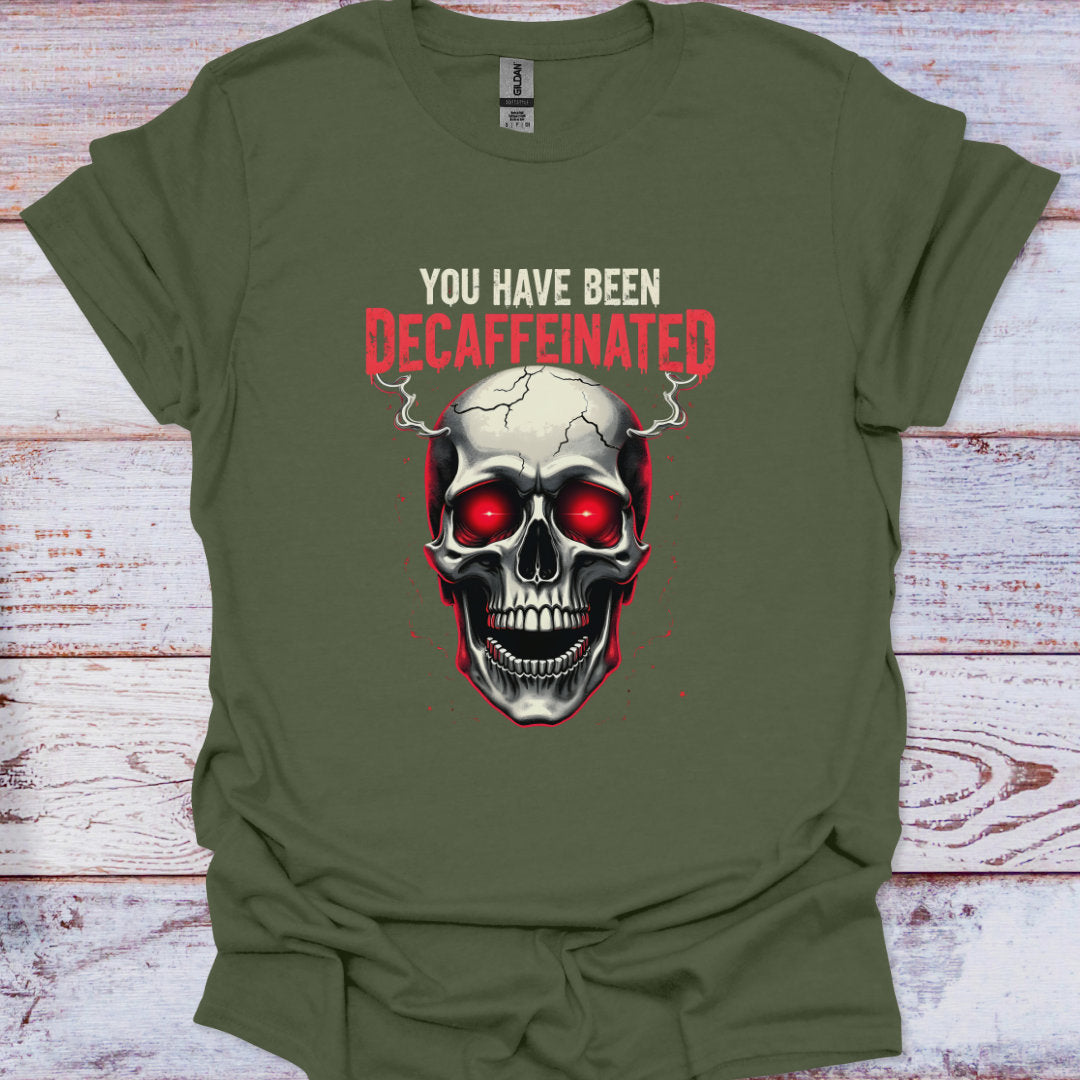 Green t-shirt with a skull graphic and text 'You have been decaffeinated' on a wooden surface.