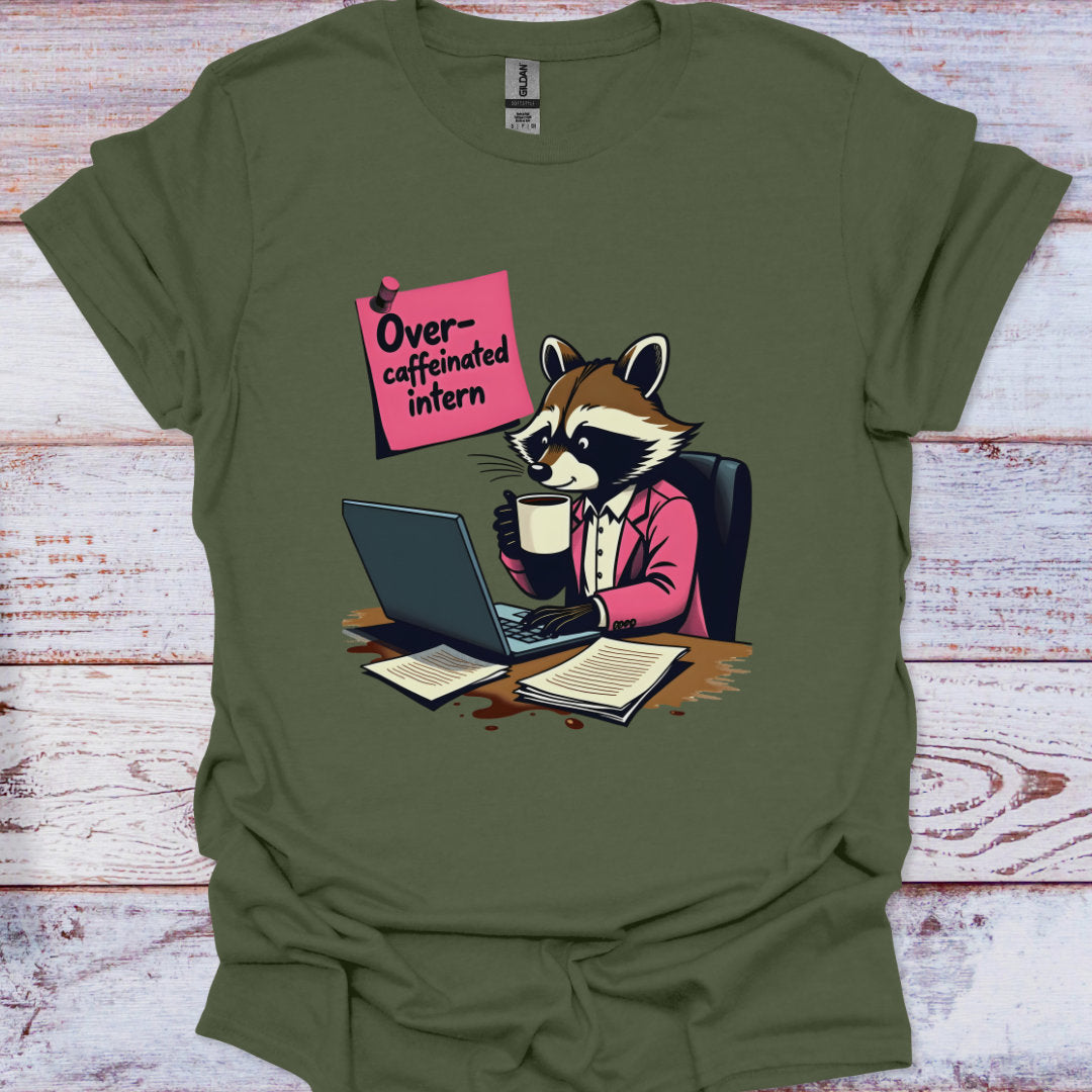 Green t-shirt with a raccoon graphic holding a coffee cup and using a laptop, with text 'Overcaffeinated intern' on a wooden surface.
