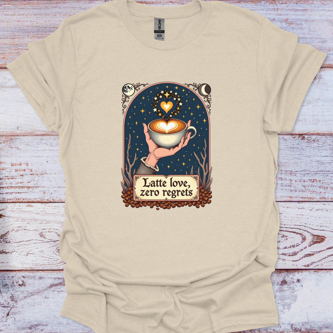Beige t-shirt with a graphic of a hand holding a coffee cup and text 'Latte love, zero regrets' on a wooden surface.