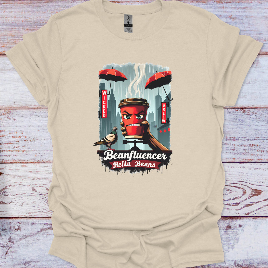Beige t-shirt with a graphic design of a coffee cup and text 'Beanfluencer Hella Beans' on a wooden surface.