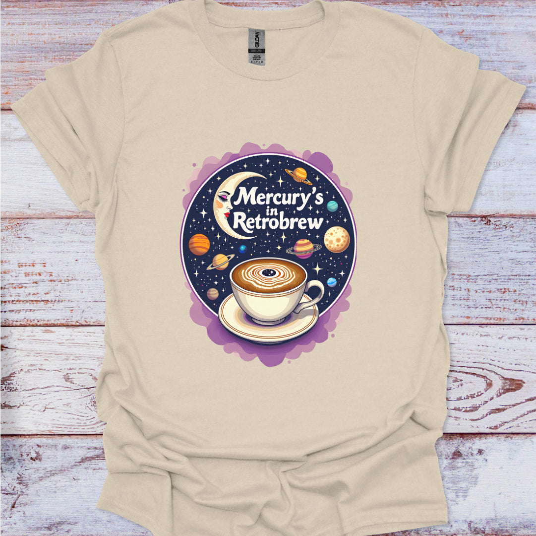 Beige t-shirt with a coffee-themed graphic design on a wooden surface