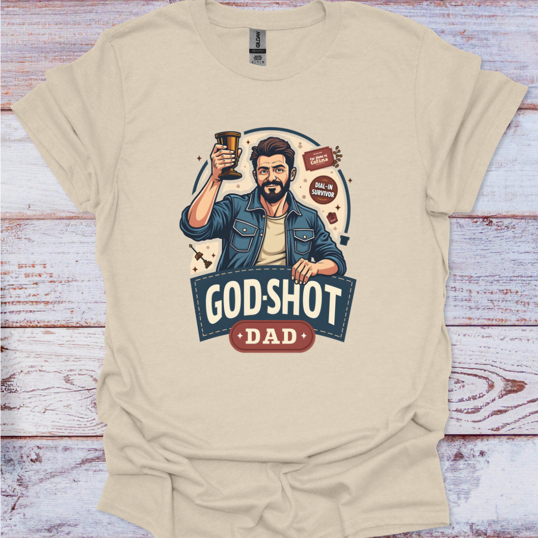 Beige t-shirt with a graphic of a man holding a beer mug and 'God-Shot Dad' text on a wooden surface.