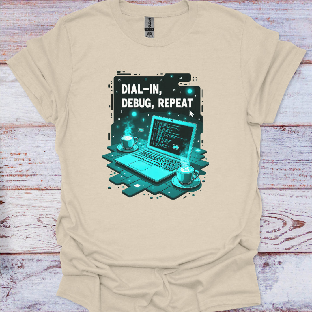 Beige t-shirt with a graphic design of a laptop and text 'Dial-In, Debug, Repeat' on a wooden surface.