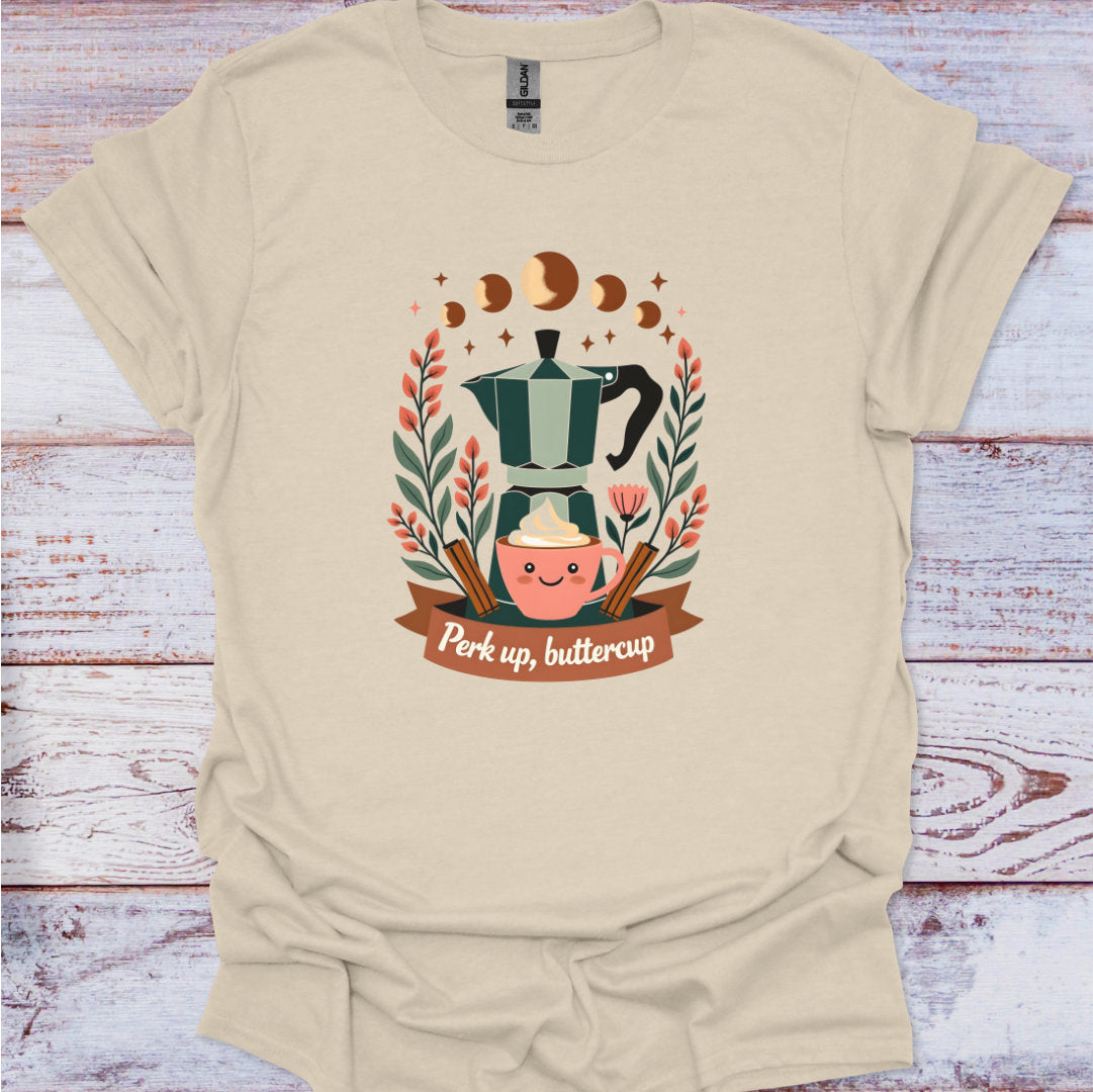 Beige t-shirt with a coffee-themed graphic and text 'Perk up, buttercup' on a wooden surface.