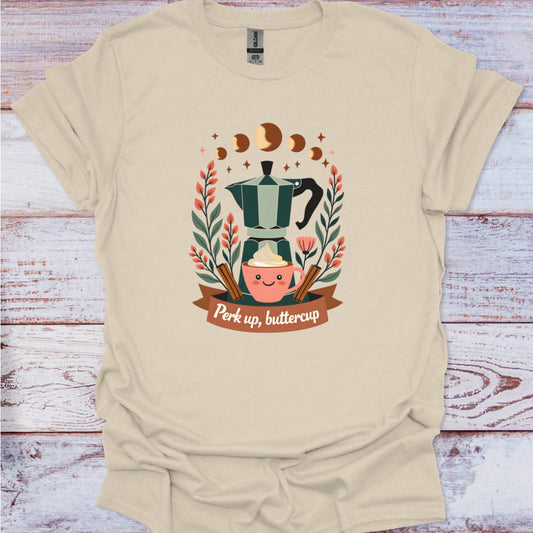Beige t-shirt with a coffee-themed graphic and text 'Perk up, buttercup' on a wooden surface.