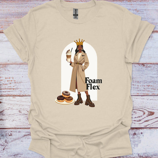 Beige t-shirt with graphic of a person holding a coffee cup and donuts, text 'Foam Flex', on a wooden surface.