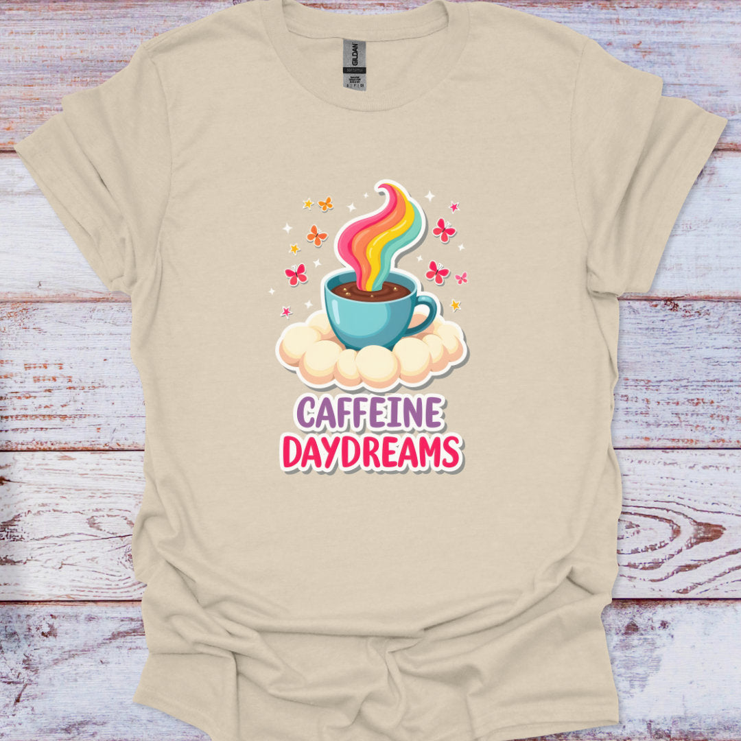 Beige t-shirt with a colorful coffee cup graphic and 'Caffeine Daydreams' text on a wooden surface.