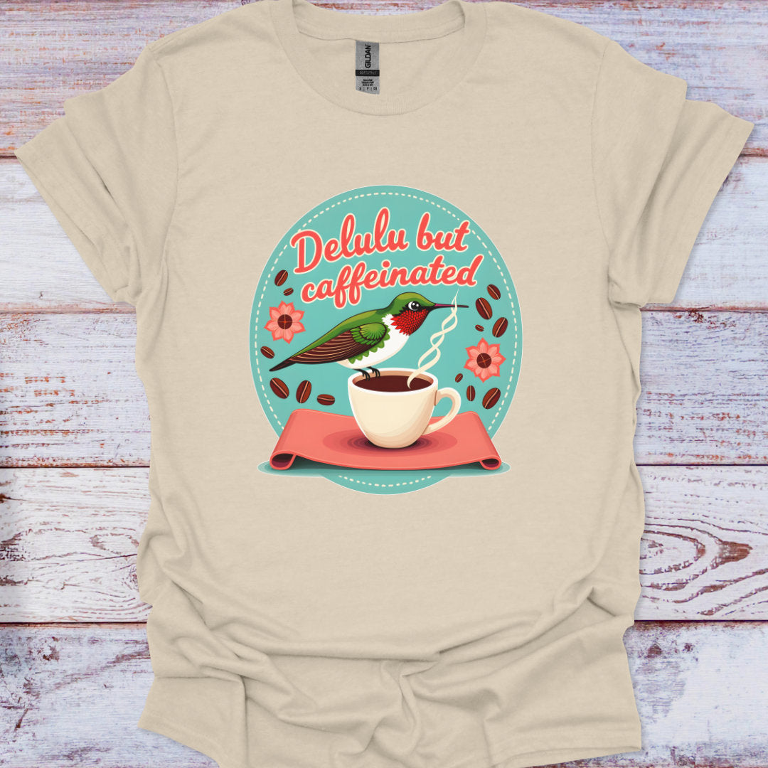 Beige t-shirt with a graphic design featuring a coffee cup and hummingbird on a wooden surface