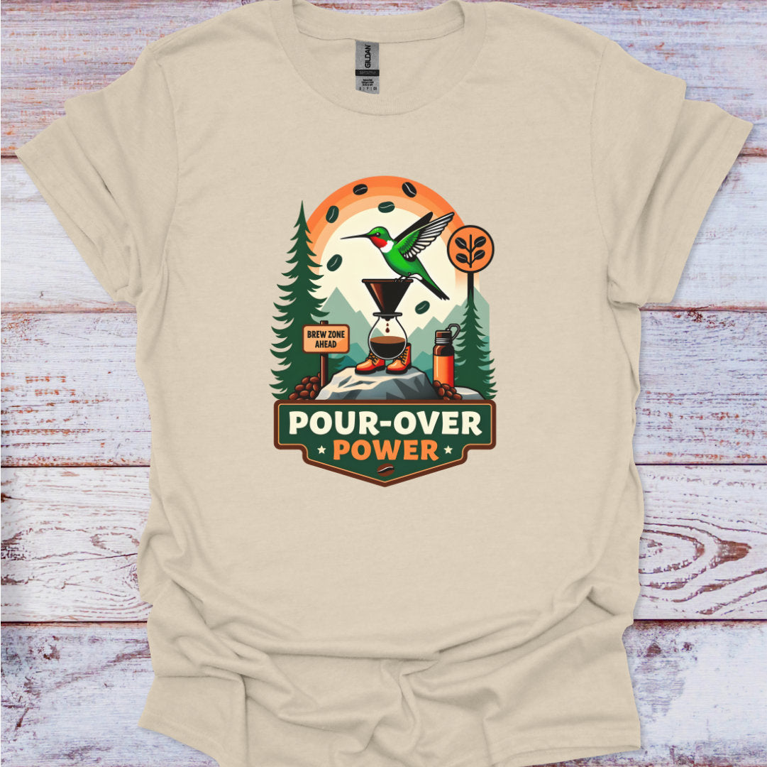 Beige t-shirt with a graphic design featuring a hummingbird and trees on a wooden surface