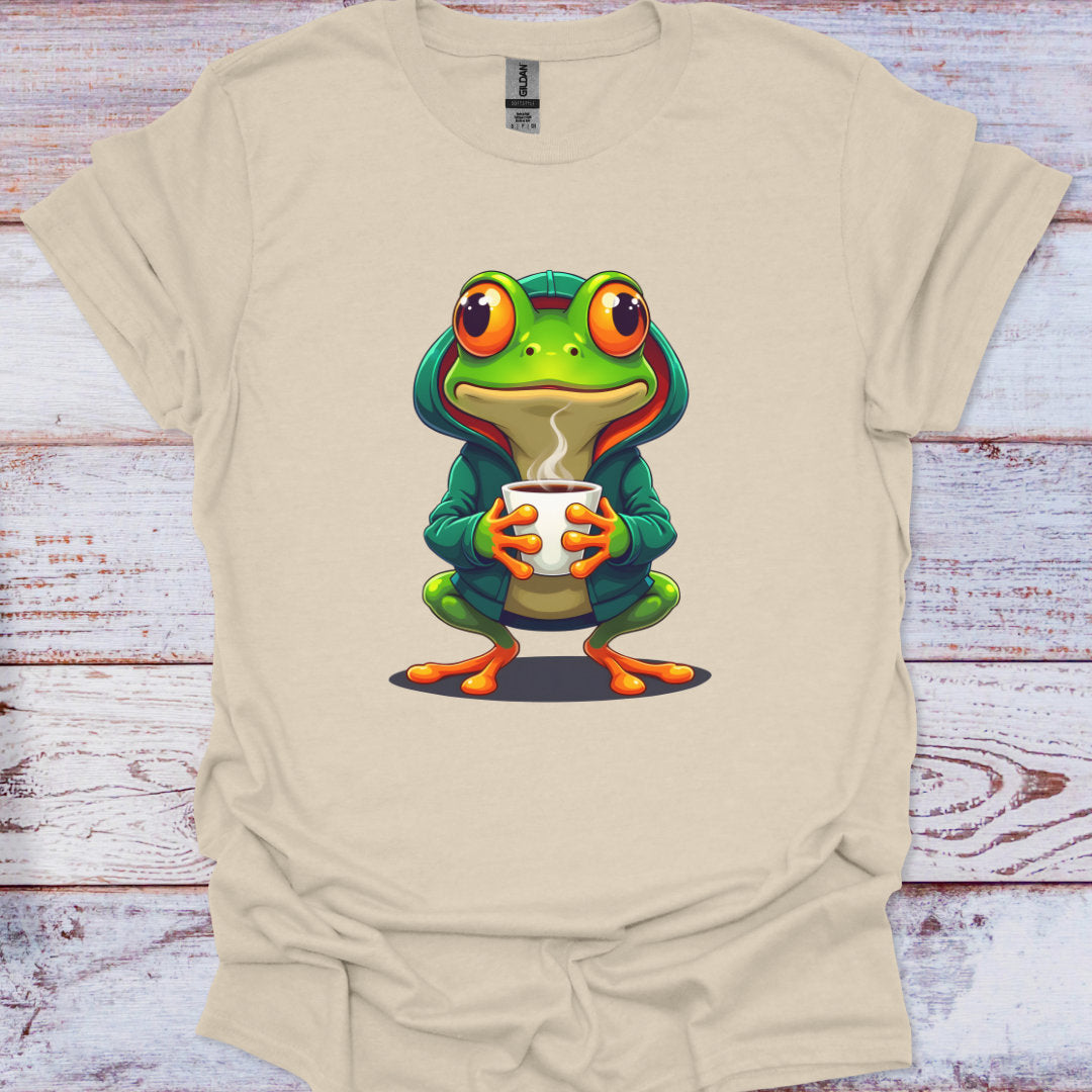 Beige t-shirt with a cartoon frog holding a cup on a wooden surface