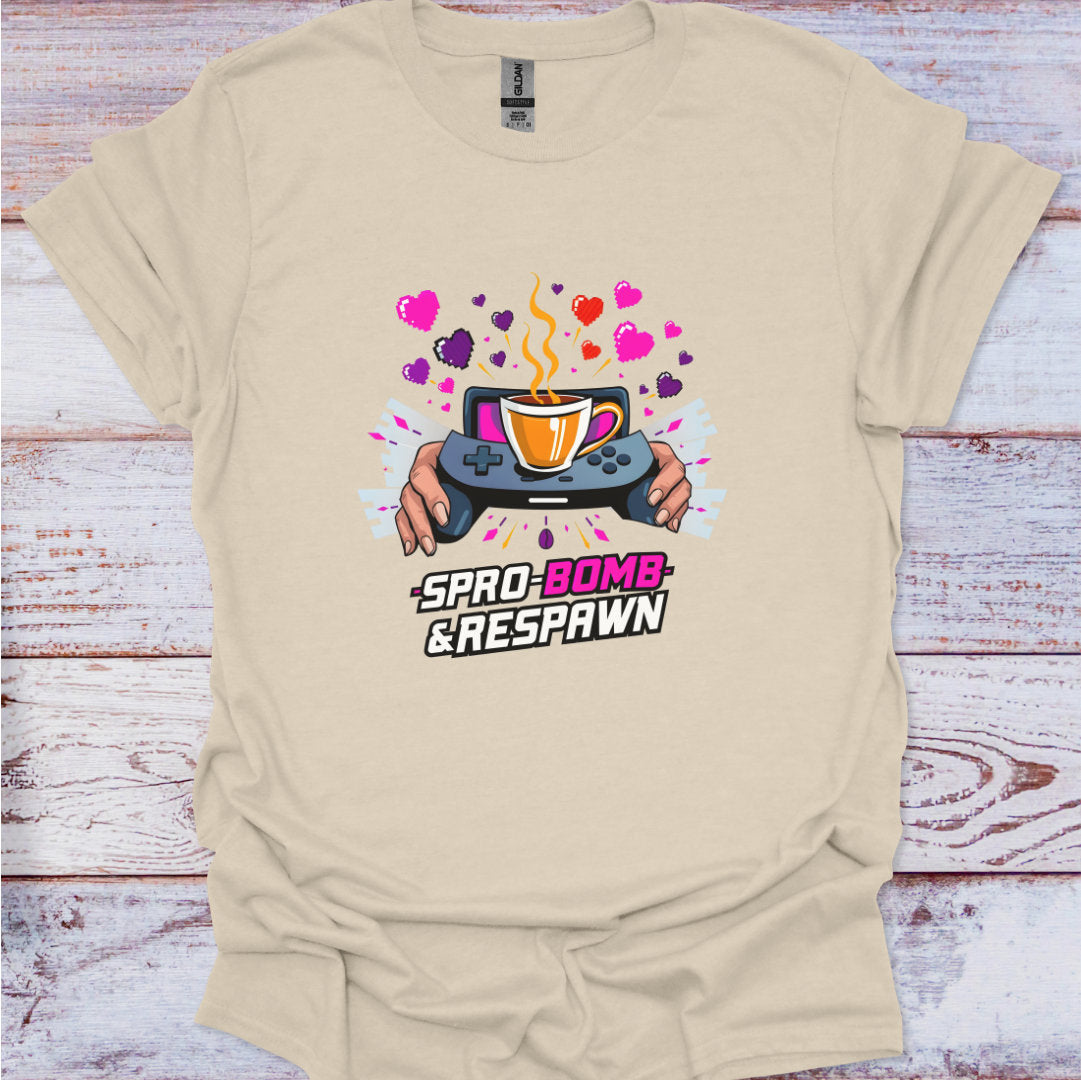 Beige t-shirt with a graphic design of a game controller and coffee cup on a wooden surface