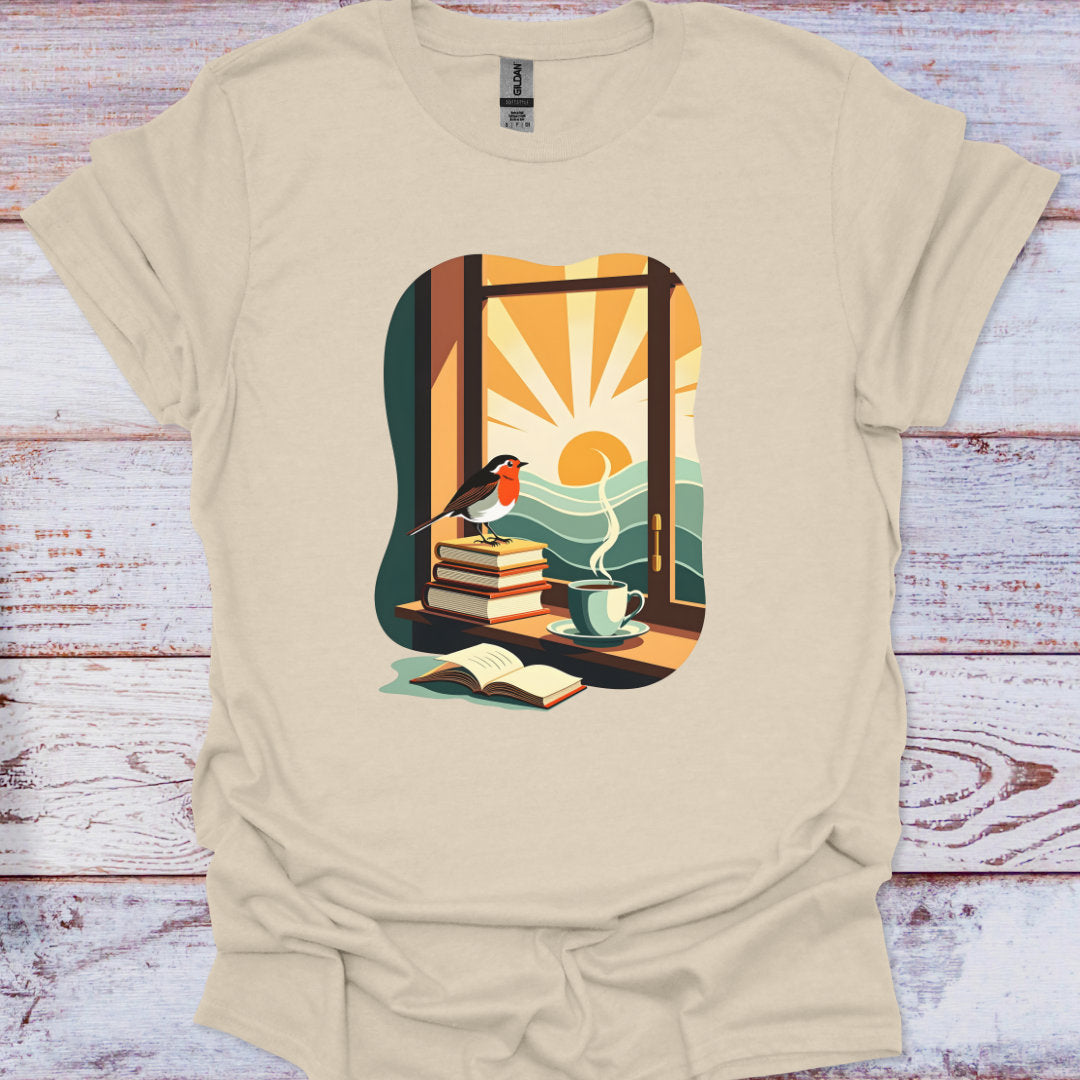 Beige t-shirt with a graphic design of a window, books, a cup, and a bird on a wooden surface.