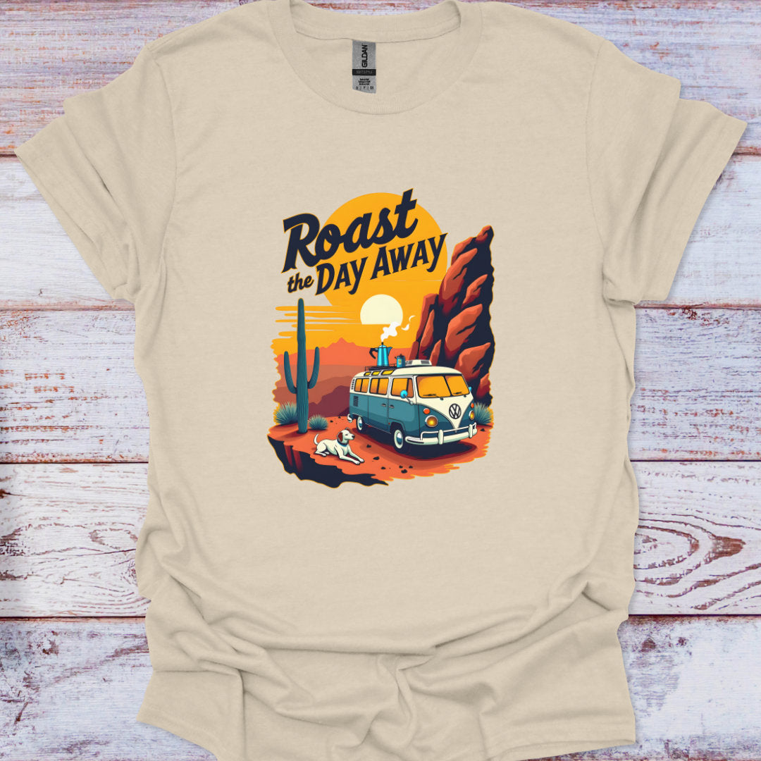 Beige t-shirt with a graphic design of a van, cactus, and text 'Roast the Day Away' on a wooden surface.
