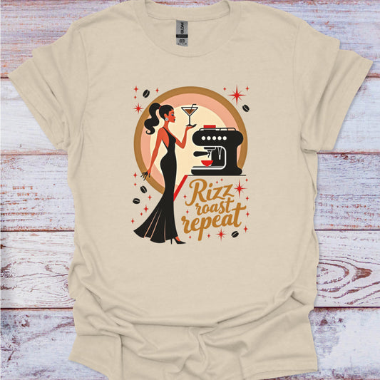 Beige t-shirt with a graphic design of a woman, coffee machine, and text 'Rizz roast repeat' on a wooden surface.