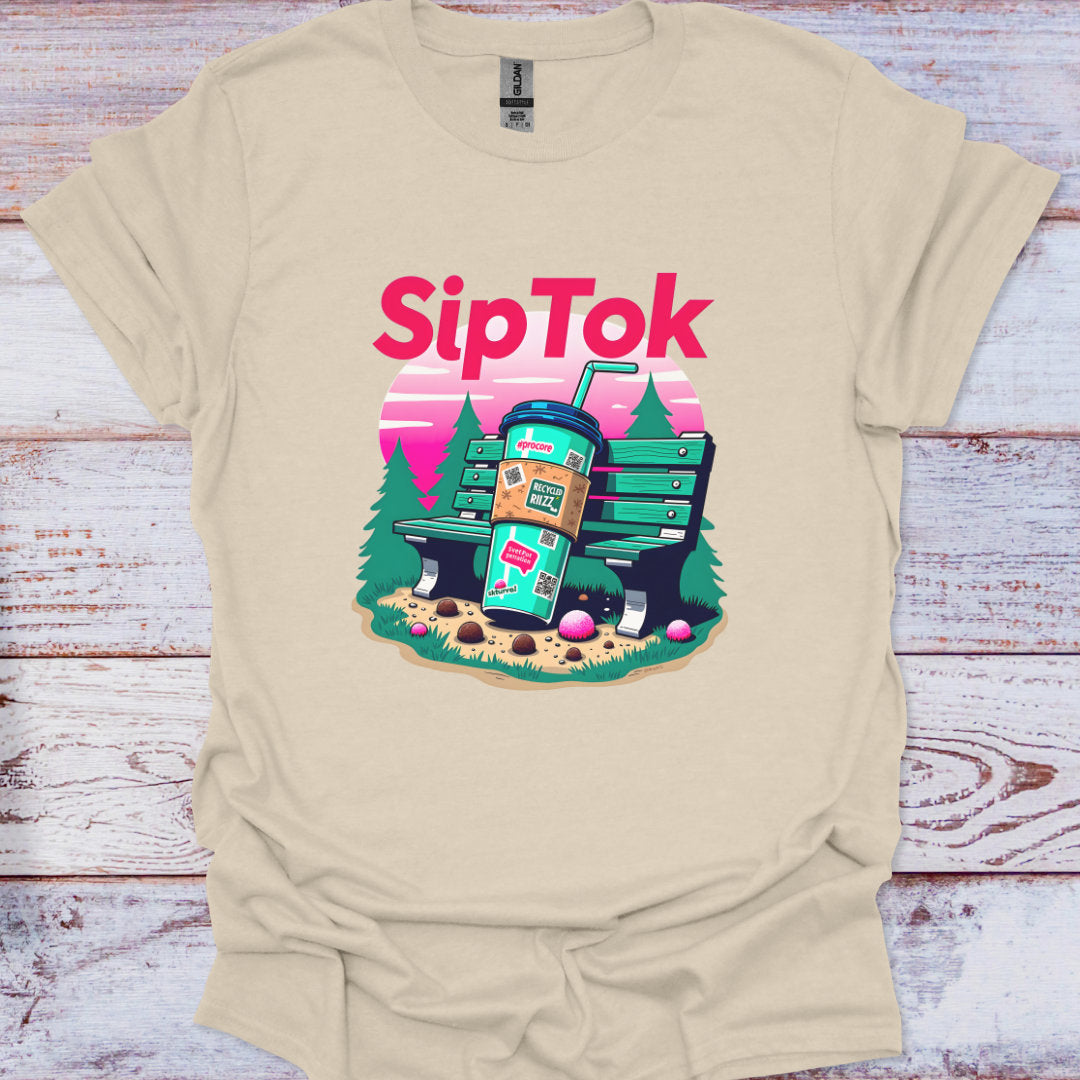 Beige t-shirt with 'SipTok' graphic design featuring a coffee cup and trees on a wooden surface.