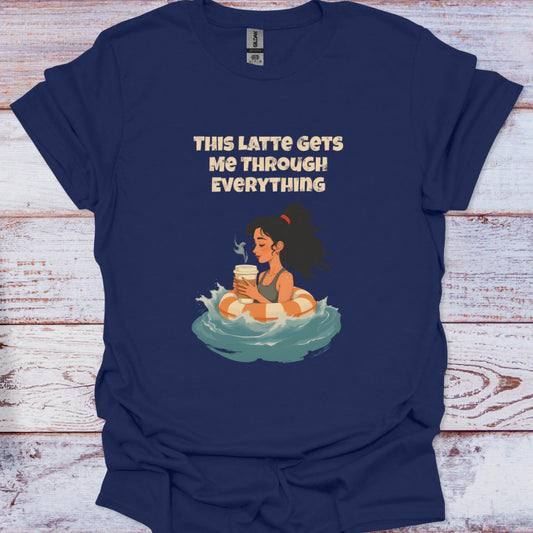 Navy blue t-shirt with a graphic of a woman holding a coffee cup and text 'This Latte Gets Me Through Everything' on a wooden surface.