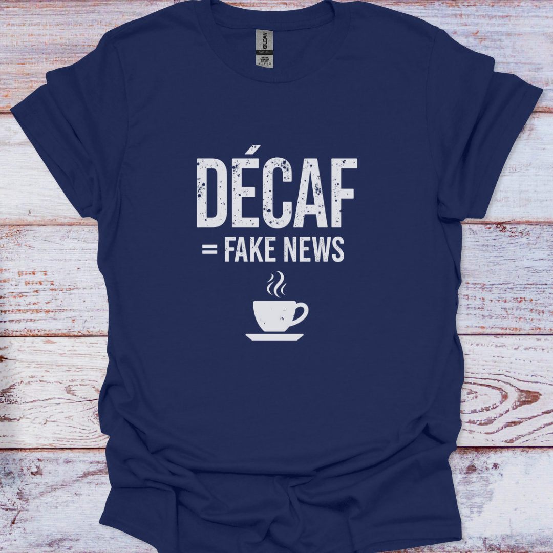 Navy blue t-shirt with 'Décaf = Fake News' text and coffee cup graphic on a wooden surface