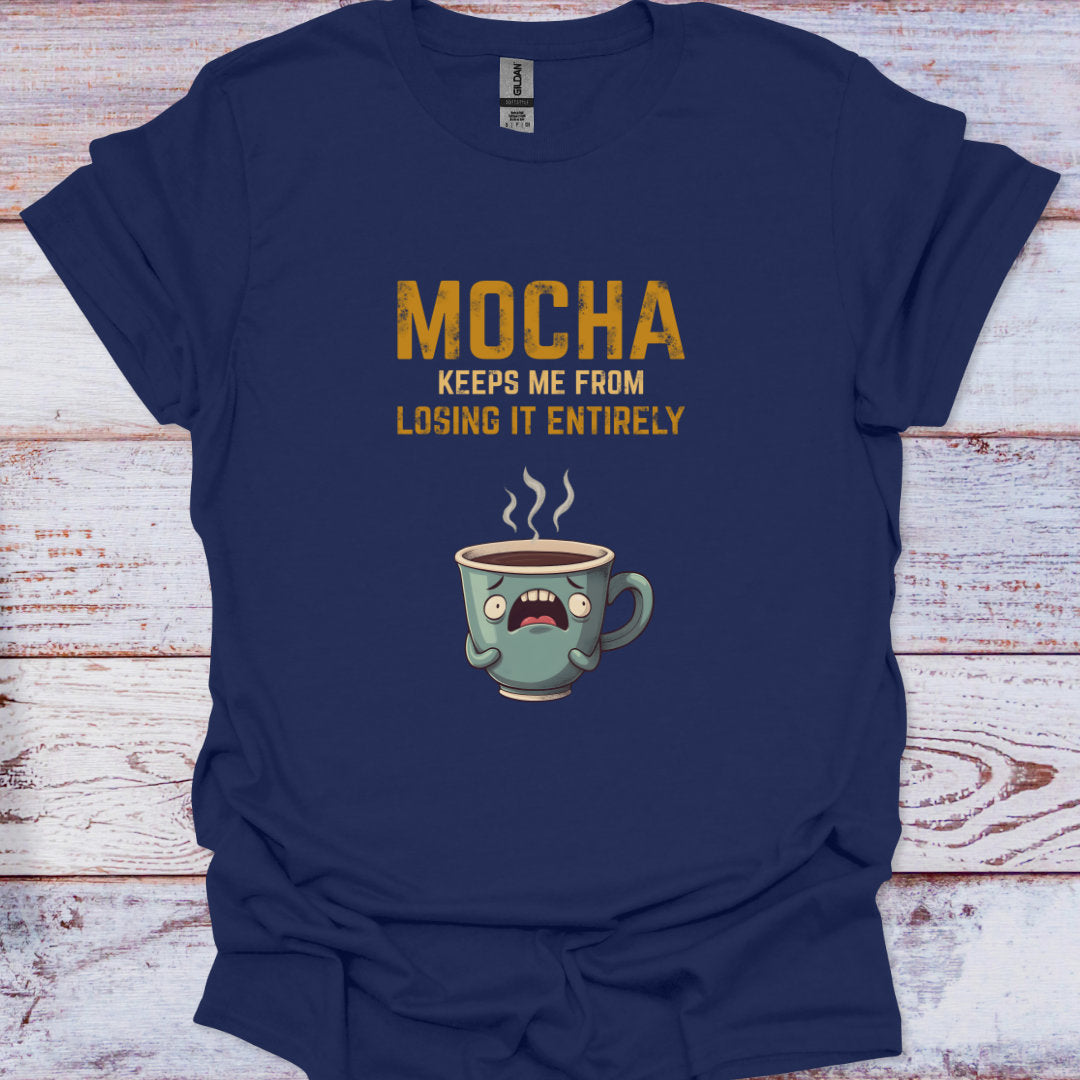 Navy blue t-shirt with a cartoon coffee mug and text on a wooden surface