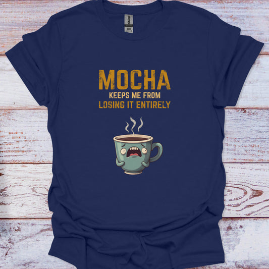Navy blue t-shirt with a cartoon coffee mug and text on a wooden surface
