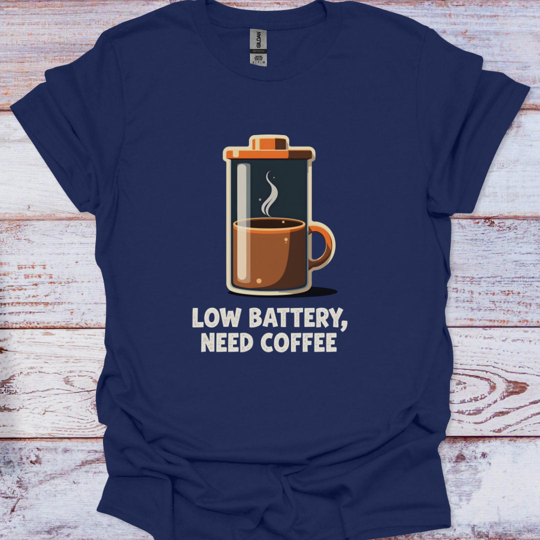 Navy blue t-shirt with a French press graphic and text 'Low battery, need coffee' on a wooden surface.