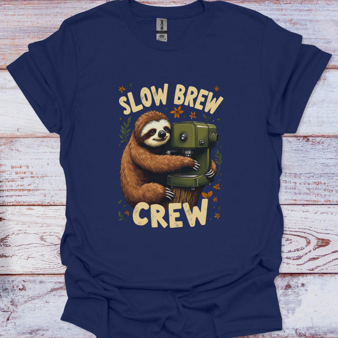 Navy blue t-shirt with a sloth holding a coffee pot and 'Slow Brew Crew' text on a wooden surface.