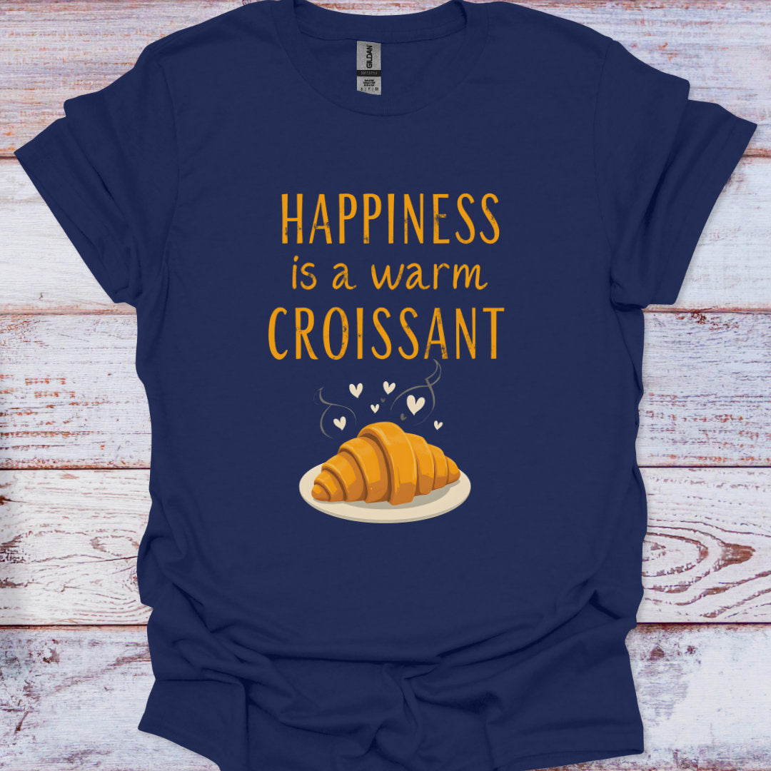 Navy blue t-shirt with a yellow croissant graphic and text on a wooden surface