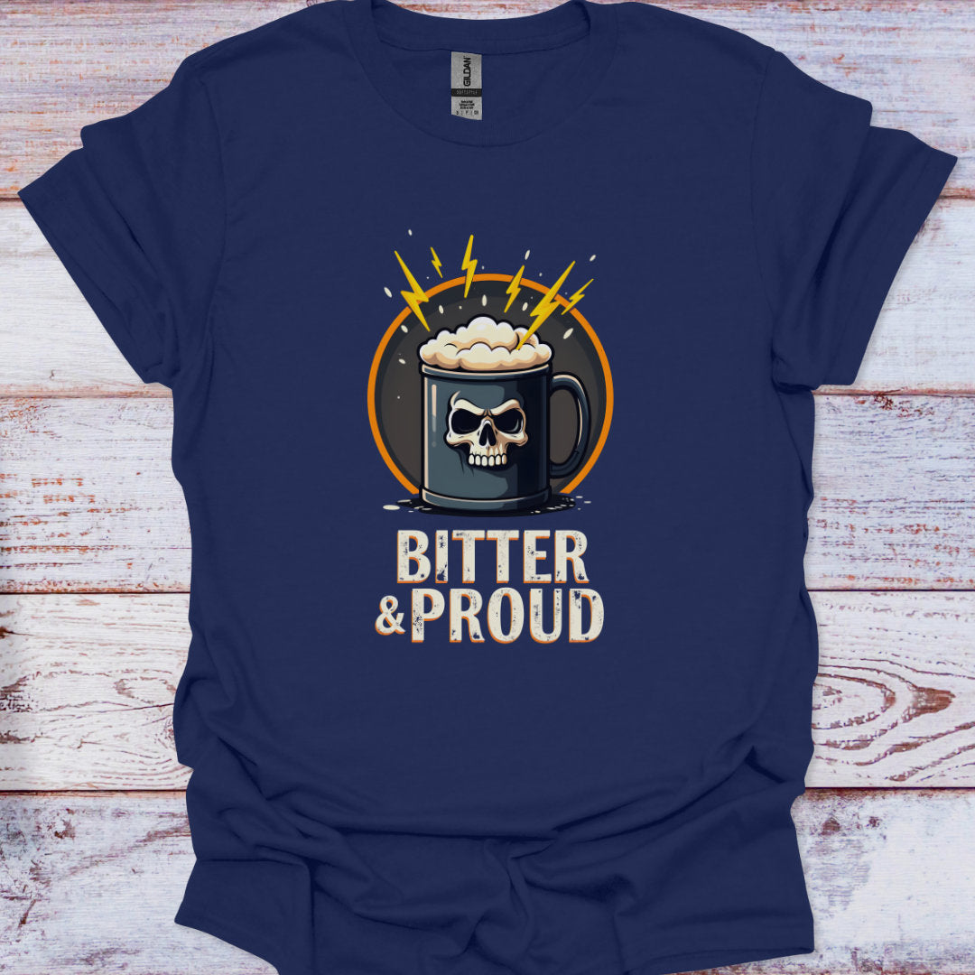 Navy blue t-shirt with a graphic of a skull in a mug and 'Bitter & Proud' text on a wooden surface.