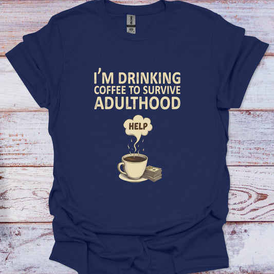 Navy blue t-shirt with a graphic of a coffee cup and money, and text 'I'm drinking coffee to survive adulthood' on a wooden surface.