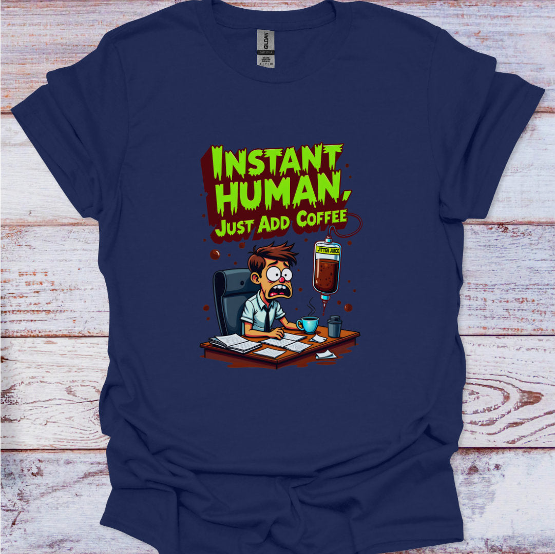Navy blue t-shirt with cartoon character and 'Instant Human, Just Add Coffee' text on a wooden surface.