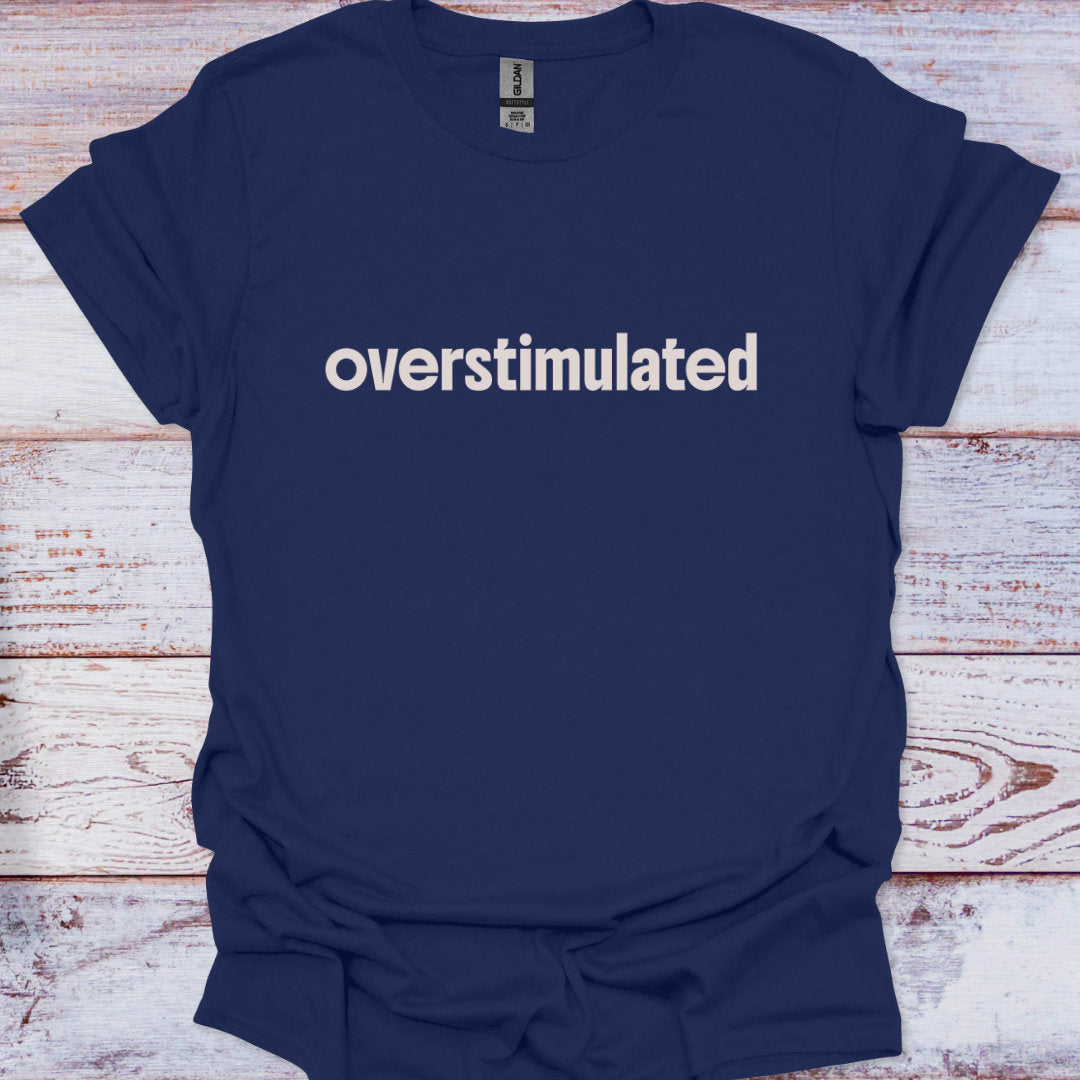 Navy blue t-shirt with 'overstimulated' text on a wooden surface