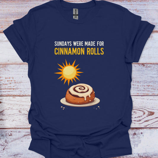 Navy blue t-shirt with a cinnamon roll graphic and text on a wooden surface