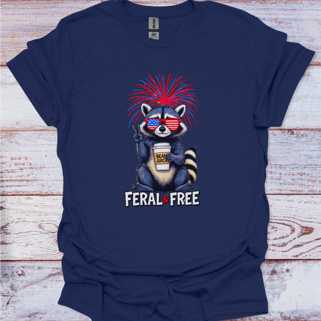 Navy blue t-shirt with a raccoon graphic and 'Feral & Free' text on a wooden surface