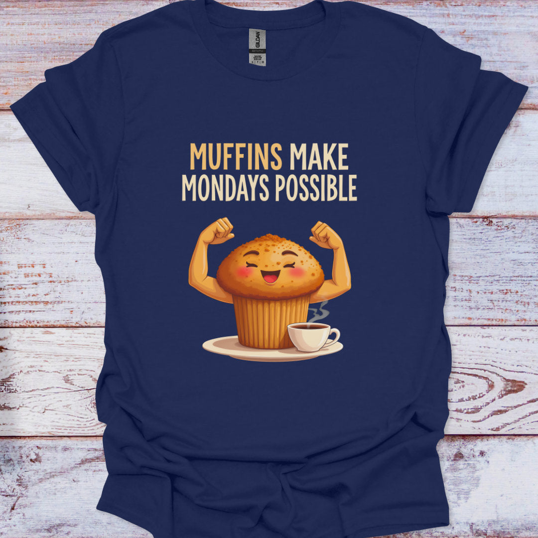Navy blue t-shirt with a cartoon muffin flexing muscles and text 'Muffins Make Mondays Possible' on a wooden surface.