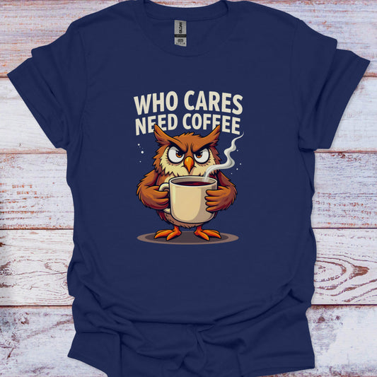 Navy blue t-shirt with an owl holding a coffee cup and text 'WHO CARES NEED COFFEE' on a wooden surface.