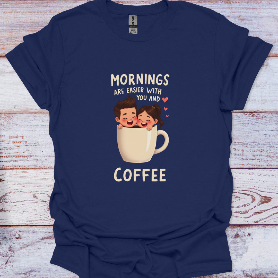 Navy blue t-shirt with a graphic of two people in a coffee cup and text 'Mornings are easier with you and coffee' on a wooden surface.
