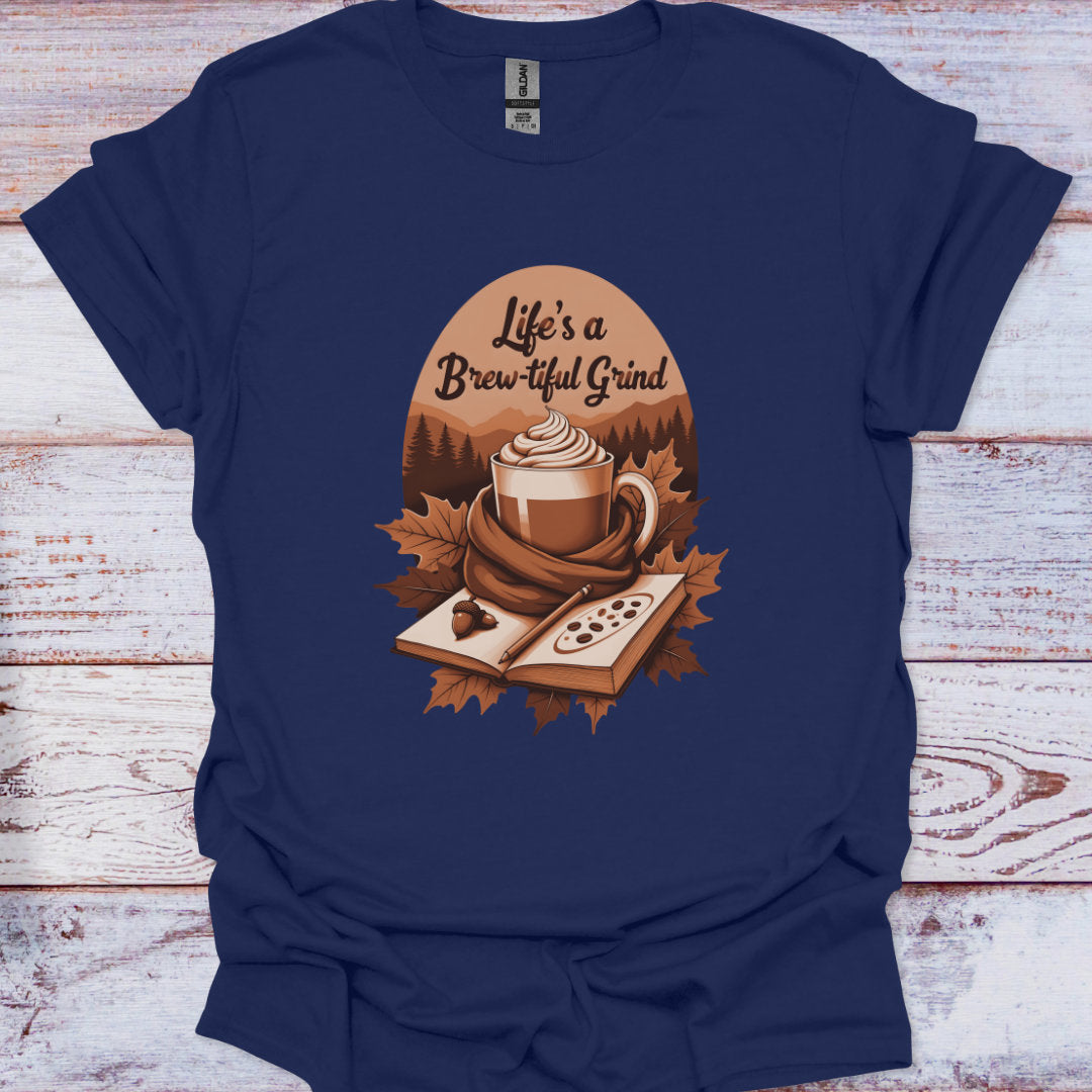 Navy blue t-shirt with a coffee-themed graphic and 'Life's a Brew-tiful Grind' text on a wooden surface.