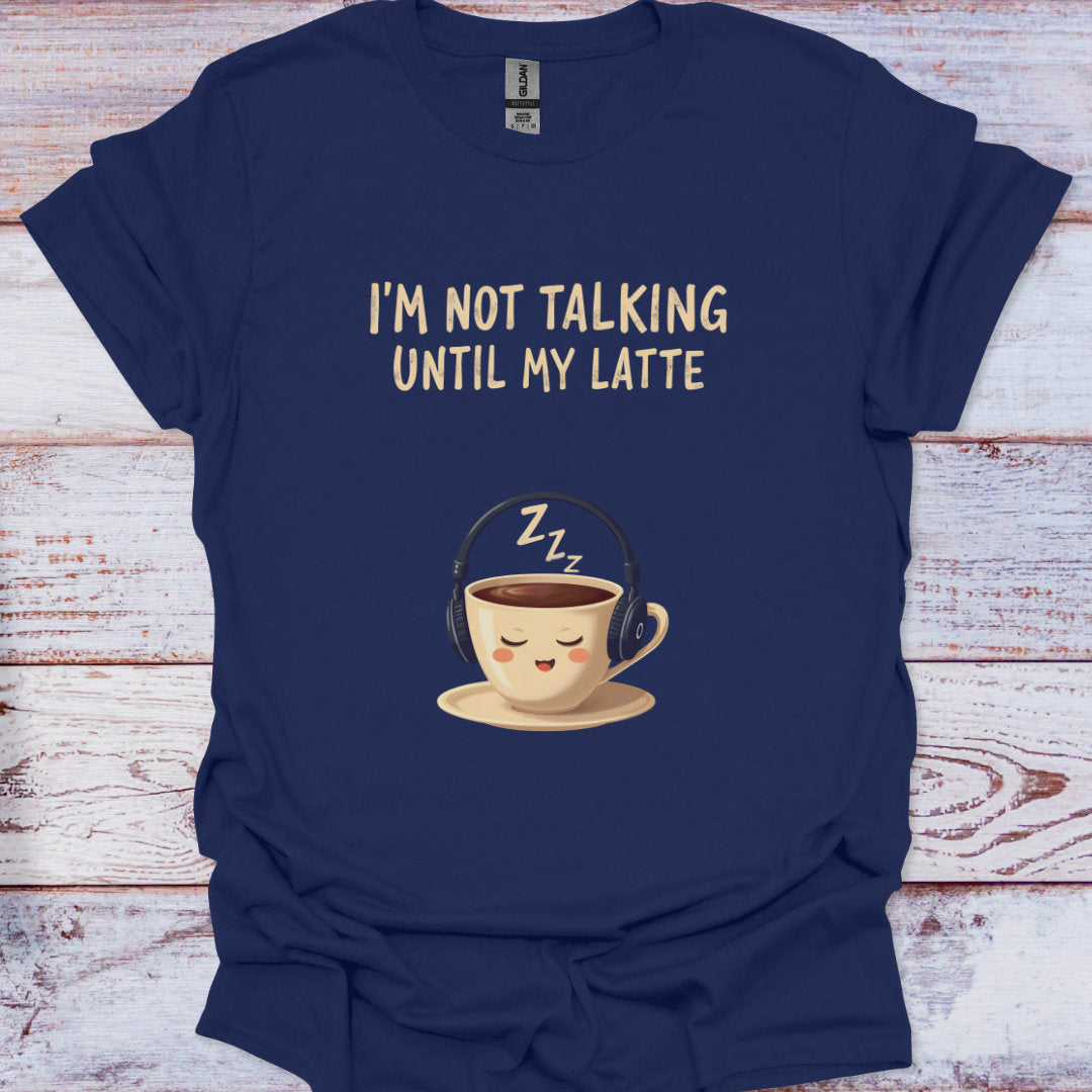 Navy blue t-shirt with a cartoon coffee cup and text 'I'm not talking until my latte' on a wooden surface.