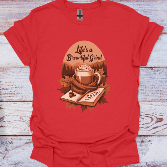 Red t-shirt with a graphic design of a coffee cup and text 'Life's a Brew-tiful Grind' on a wooden surface.