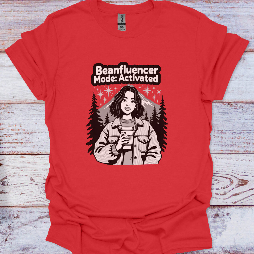 Red t-shirt with graphic design and text 'Beanfluencer Mode: Activated' on a wooden surface