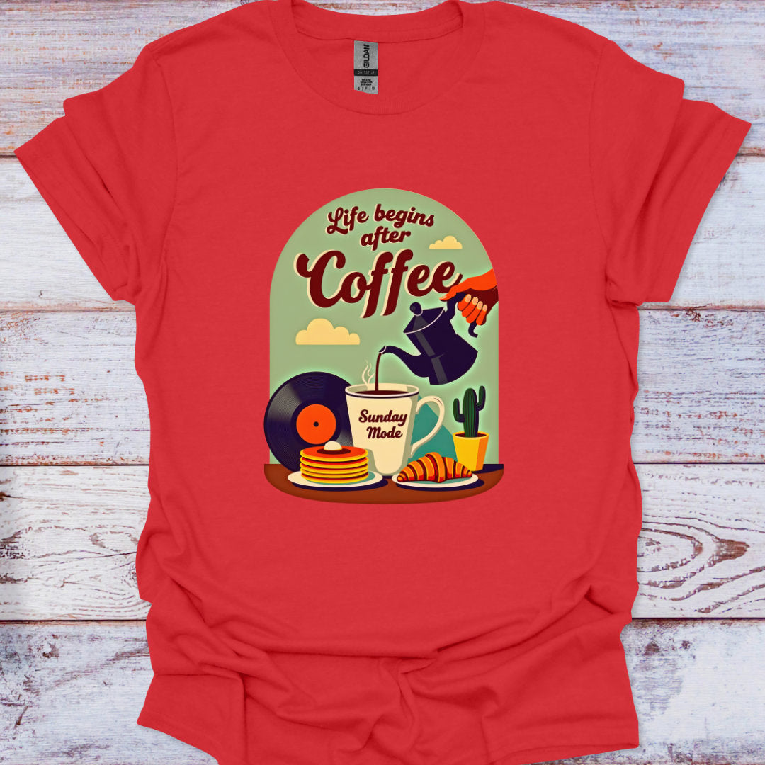 Red t-shirt with a graphic design of coffee-themed illustrations on a wooden surface.