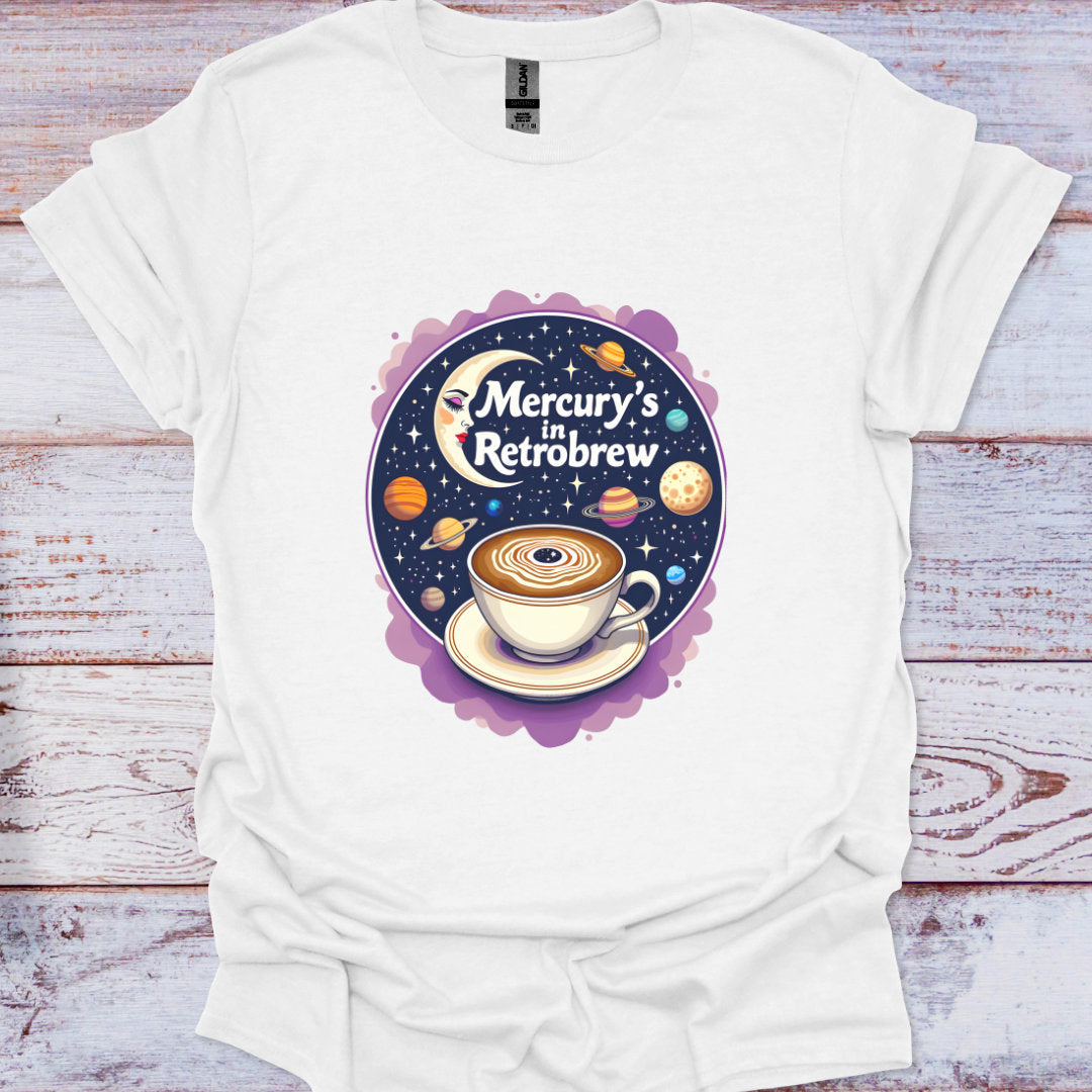 White t-shirt with a graphic design of a coffee cup and celestial elements on a wooden surface