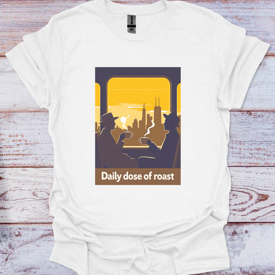 White t-shirt with graphic design of two people on a train and 'Daily dose of roast' text, on a wooden surface.