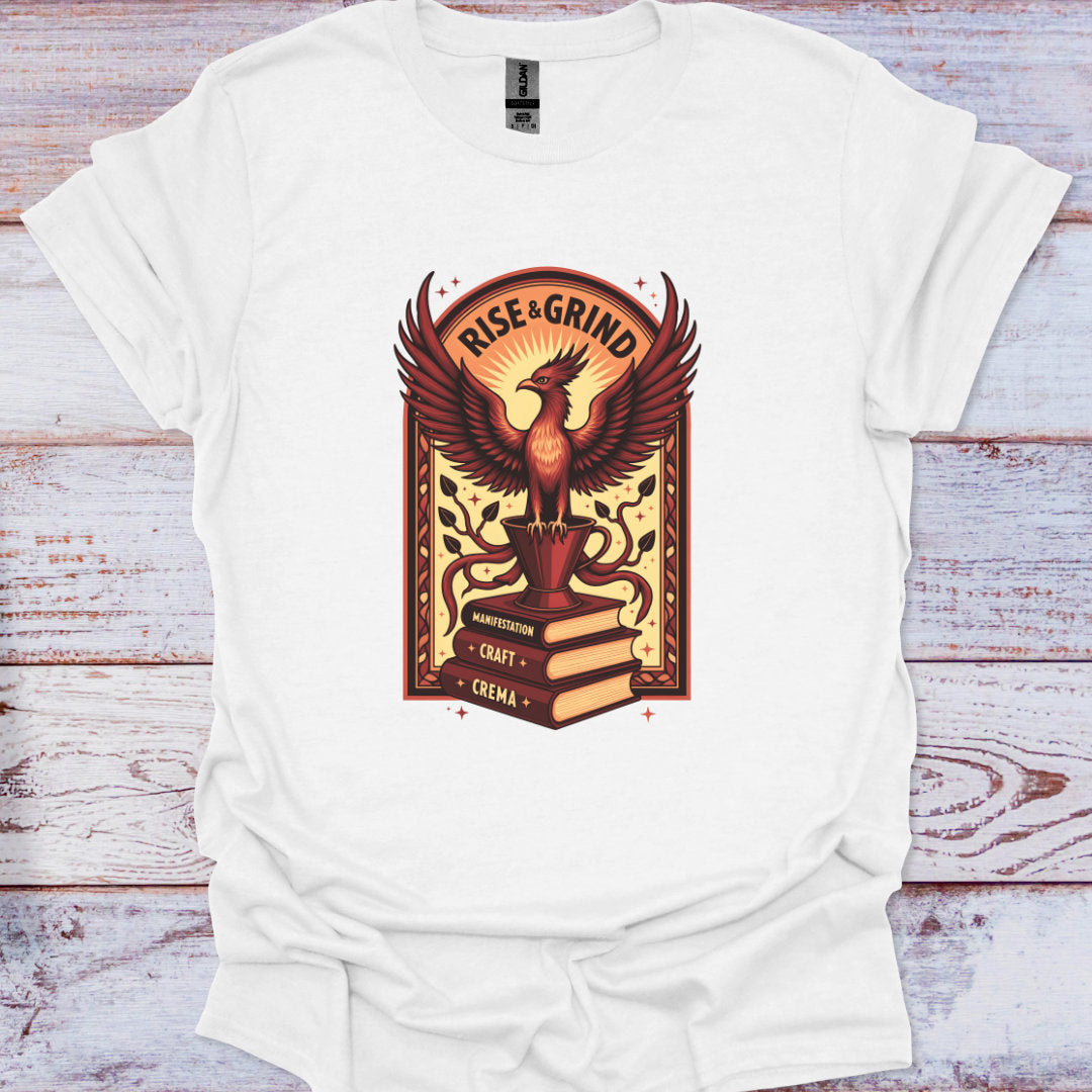 White t-shirt with a phoenix design and 'Rise & Grind' text on a wooden surface