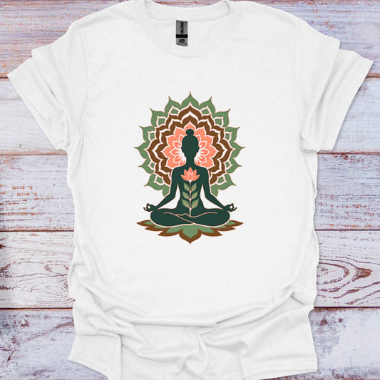 White t-shirt with a mandala design featuring a meditating figure on a wooden surface